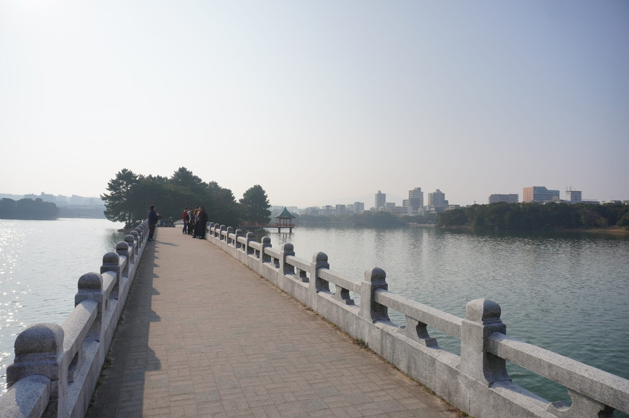 ทางเดินริมน้ำในฟุกุโอกะ มีศาลาริมน้ำและกลุ่มคนเดินเล่น