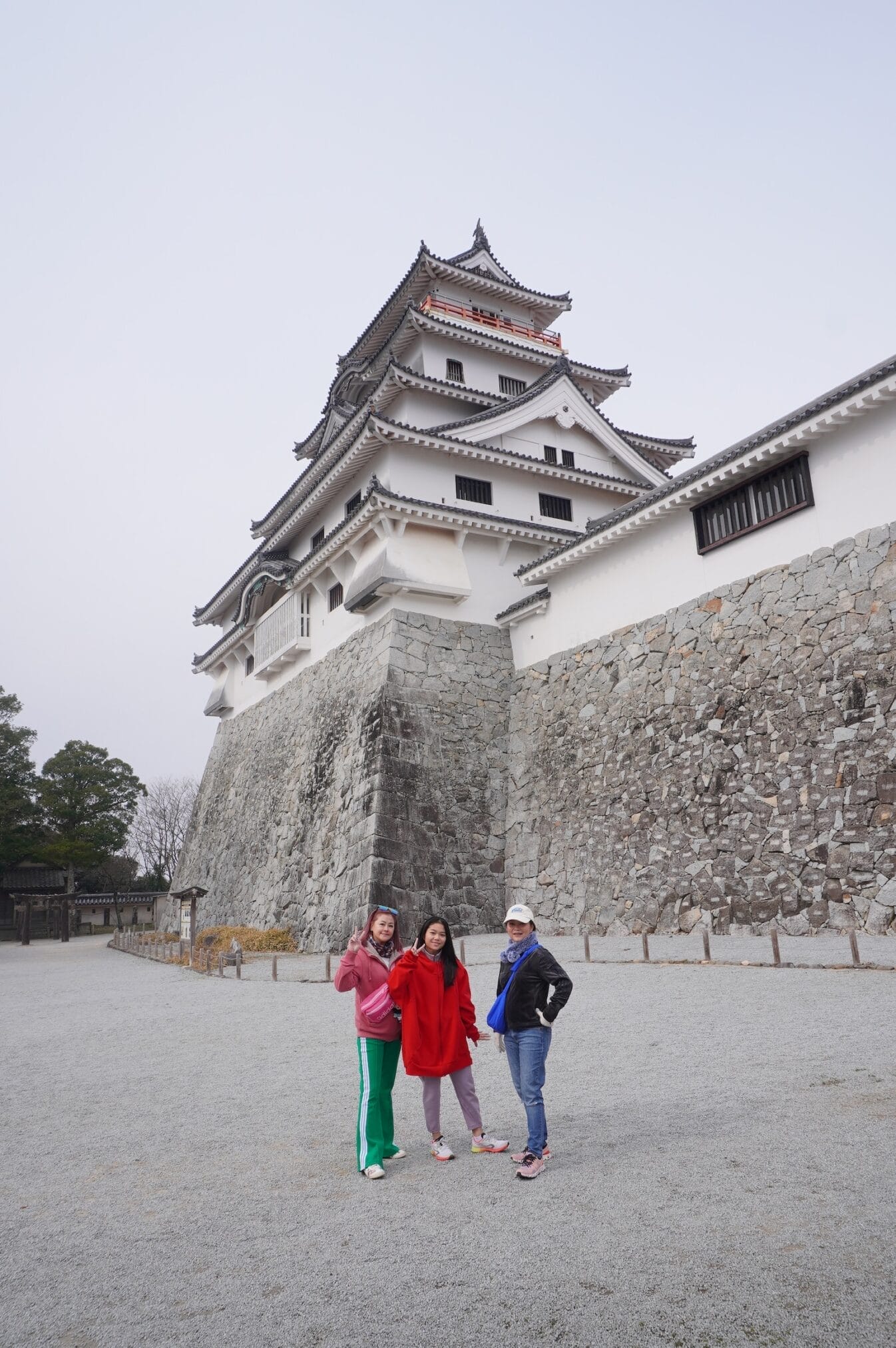 ผู้หญิงสามคนถ่ายรูปหน้าปราสาท Akizuki ในฟุกุโอกะระหว่างทริปขับรถเที่ยวคิวชู