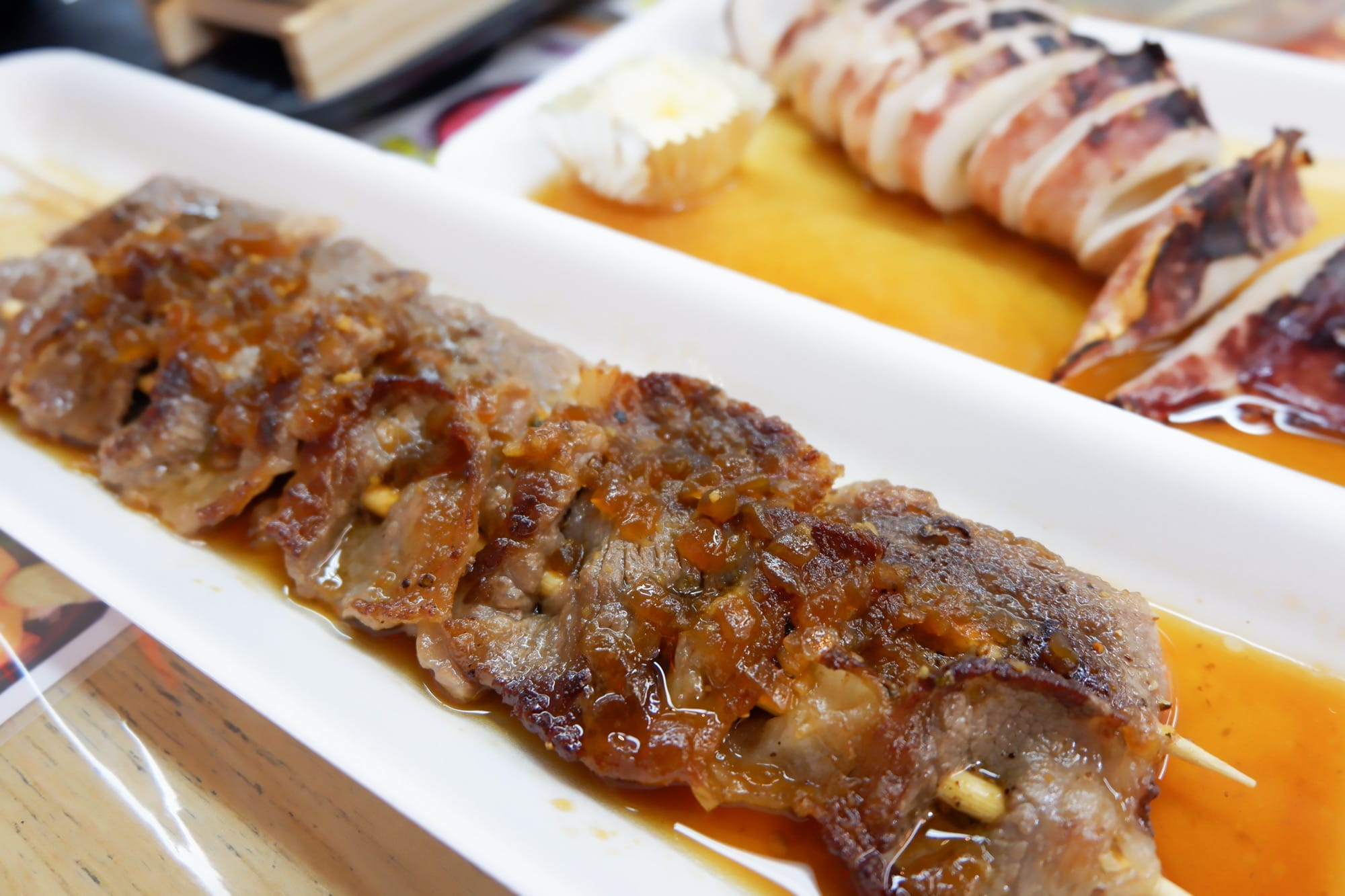 เนื้อเสียบไม้ย่างราดซอสและปลาหมึกย่าง เป็นส่วนหนึ่งของทริปขับรถจากฮอกไกโดถึงโตเกียว