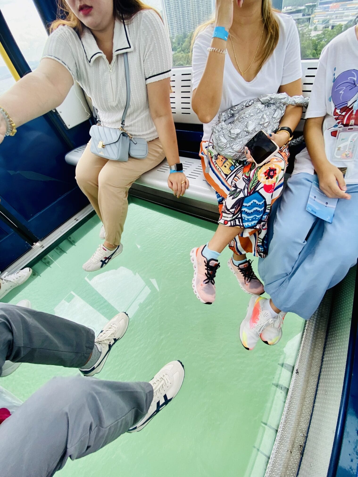 ผู้คนนั่งในกระเช้าพื้นกระจกใส มองเห็นวิวฮ่องกง กิน เที่ยว ไหว้พระ