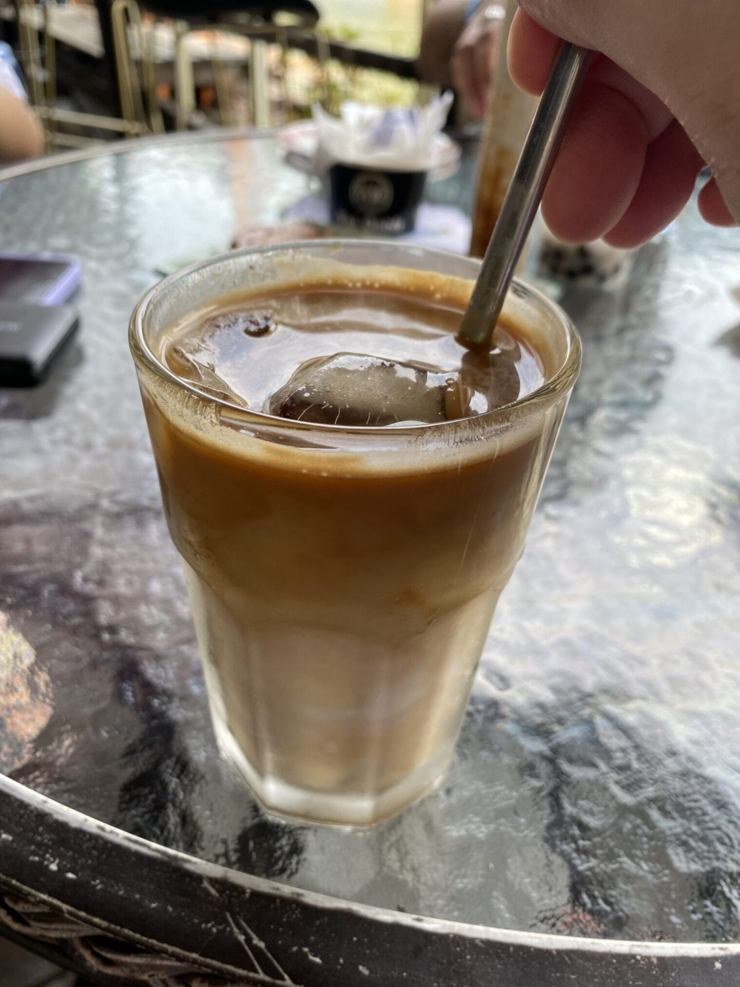 กาแฟเย็นในแก้วบนโต๊ะกระจก กิน เที่ยว ไหว้พระ ฮ่องกง