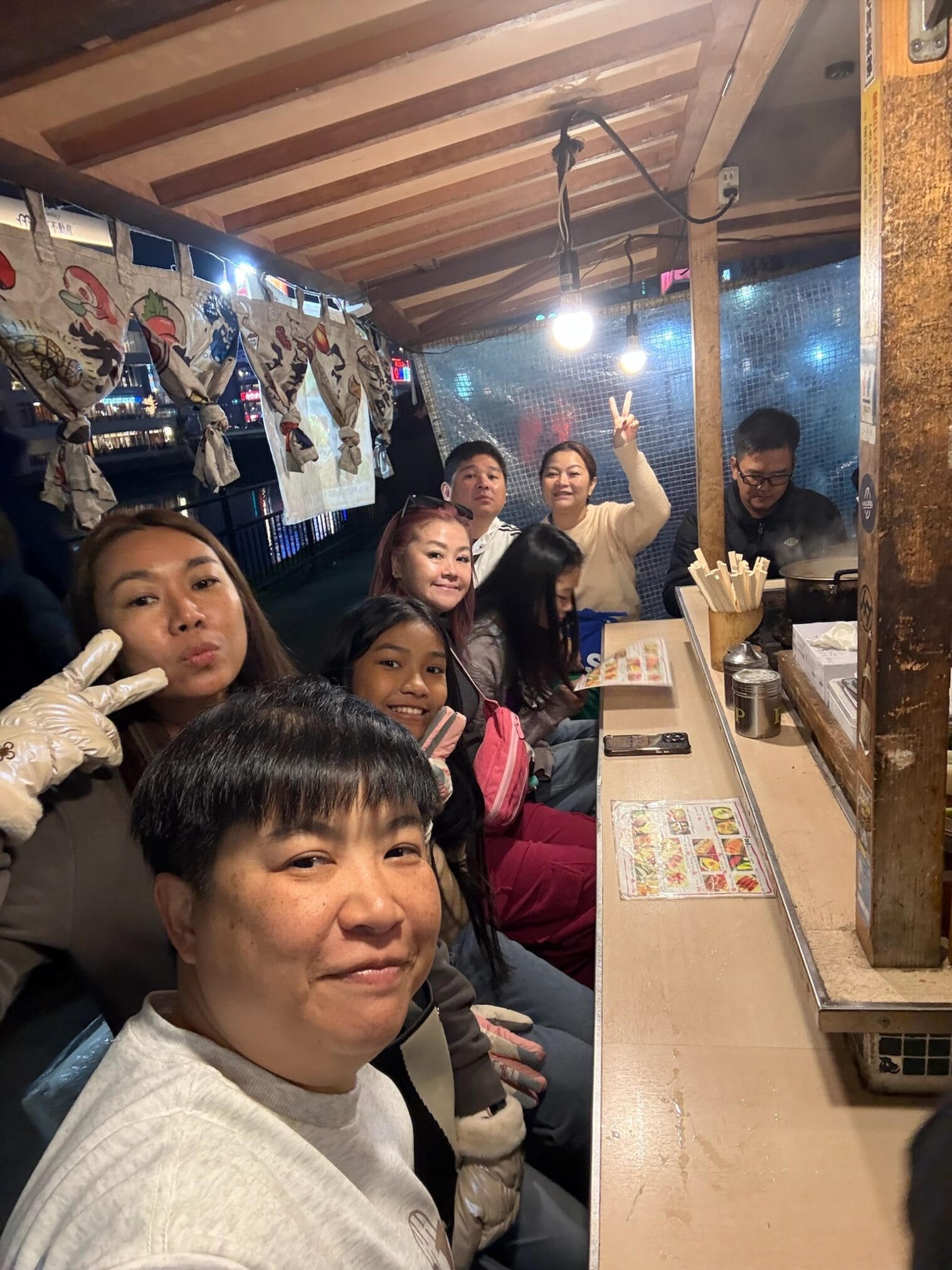 กลุ่มนักท่องเที่ยวทานอาหารที่แผงขายอาหารริมทางในฟุกุโอกะระหว่างขับรถเที่ยวคิวชู