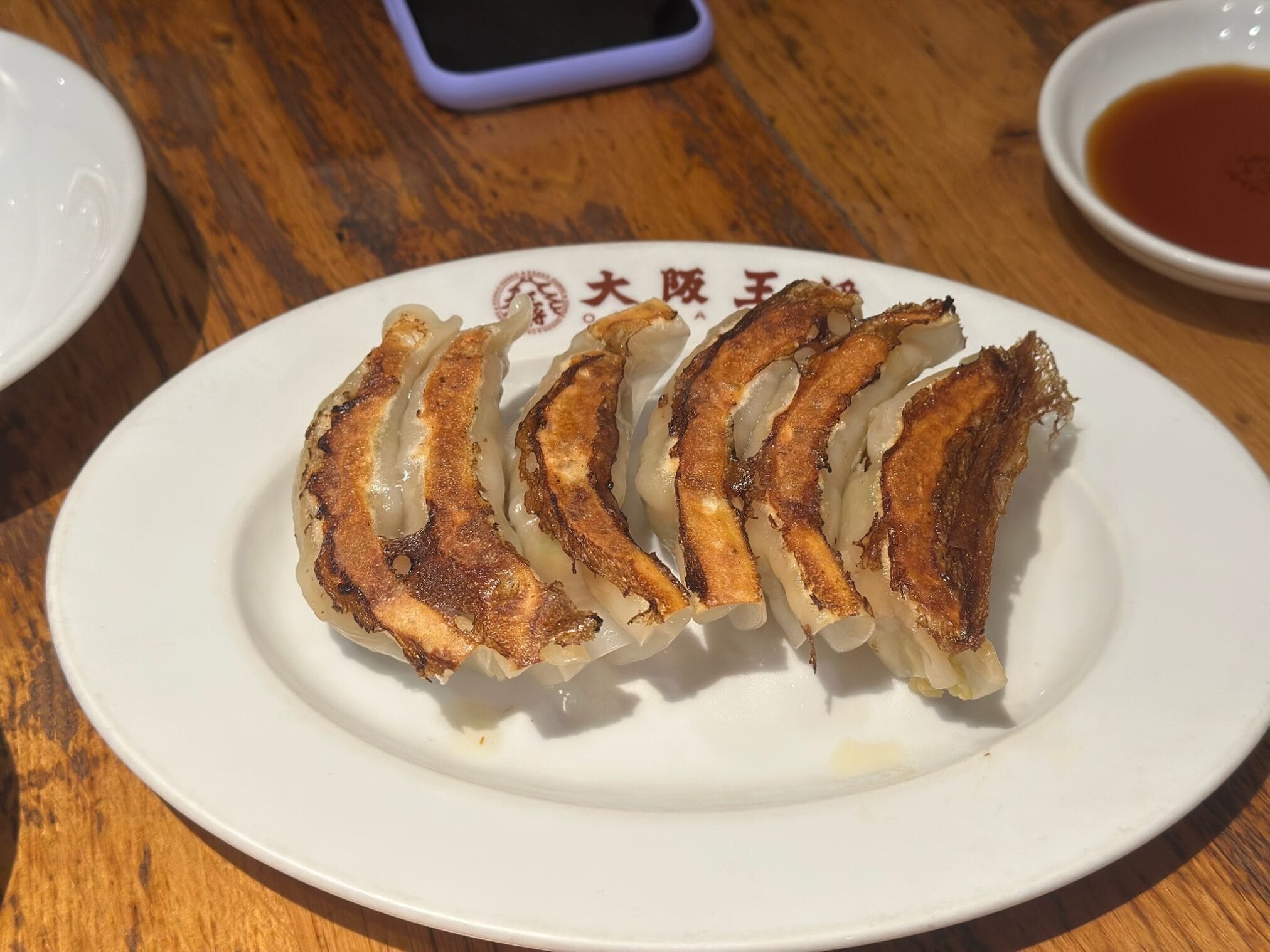 เกี๊ยวซ่าทอดกรอบบนจานสีขาว ร้านโอซาก้าโอโช เหมาะสำหรับบทความรีวิว "ขับรถเที่ยวภูมิภาคคิวชู