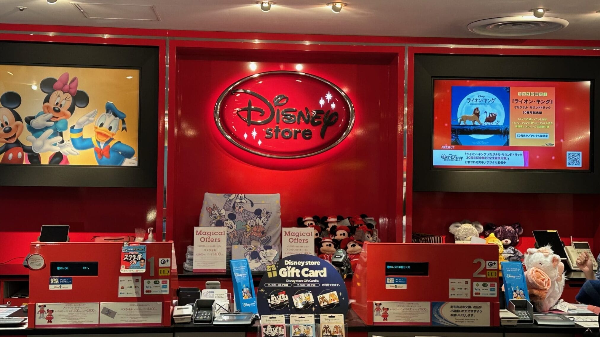 เคาน์เตอร์แคชเชียร์ร้าน Disney Store มีป้าย "Disney Store Gift Card" และของที่ระลึก