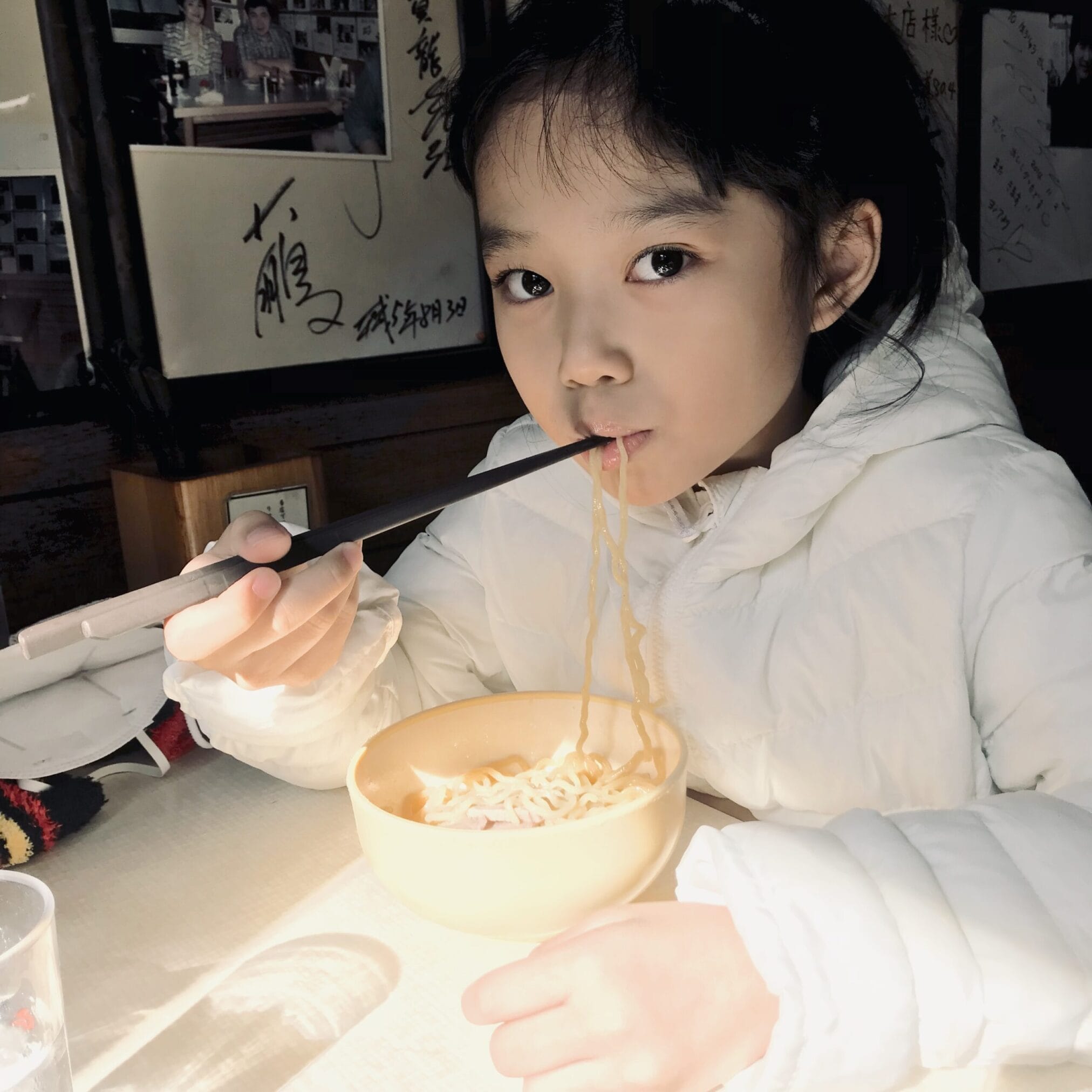 เด็กหญิงกินราเม็งในร้านอาหารระหว่างทริปขับรถจากฮอกไกโดถึงโตเกียว