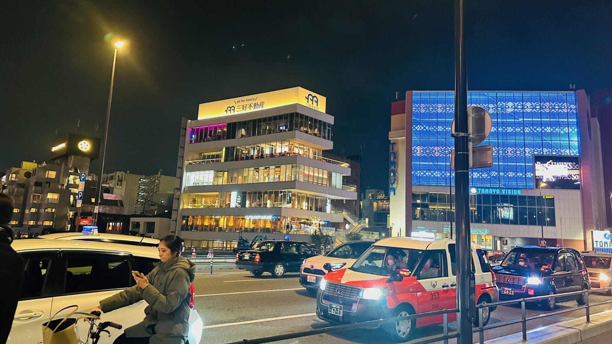 ถนนฟุกุโอกะตอนกลางคืน มีแท็กซี่, อาคาร Miyoshi Real Estate และ Tamaya Vision