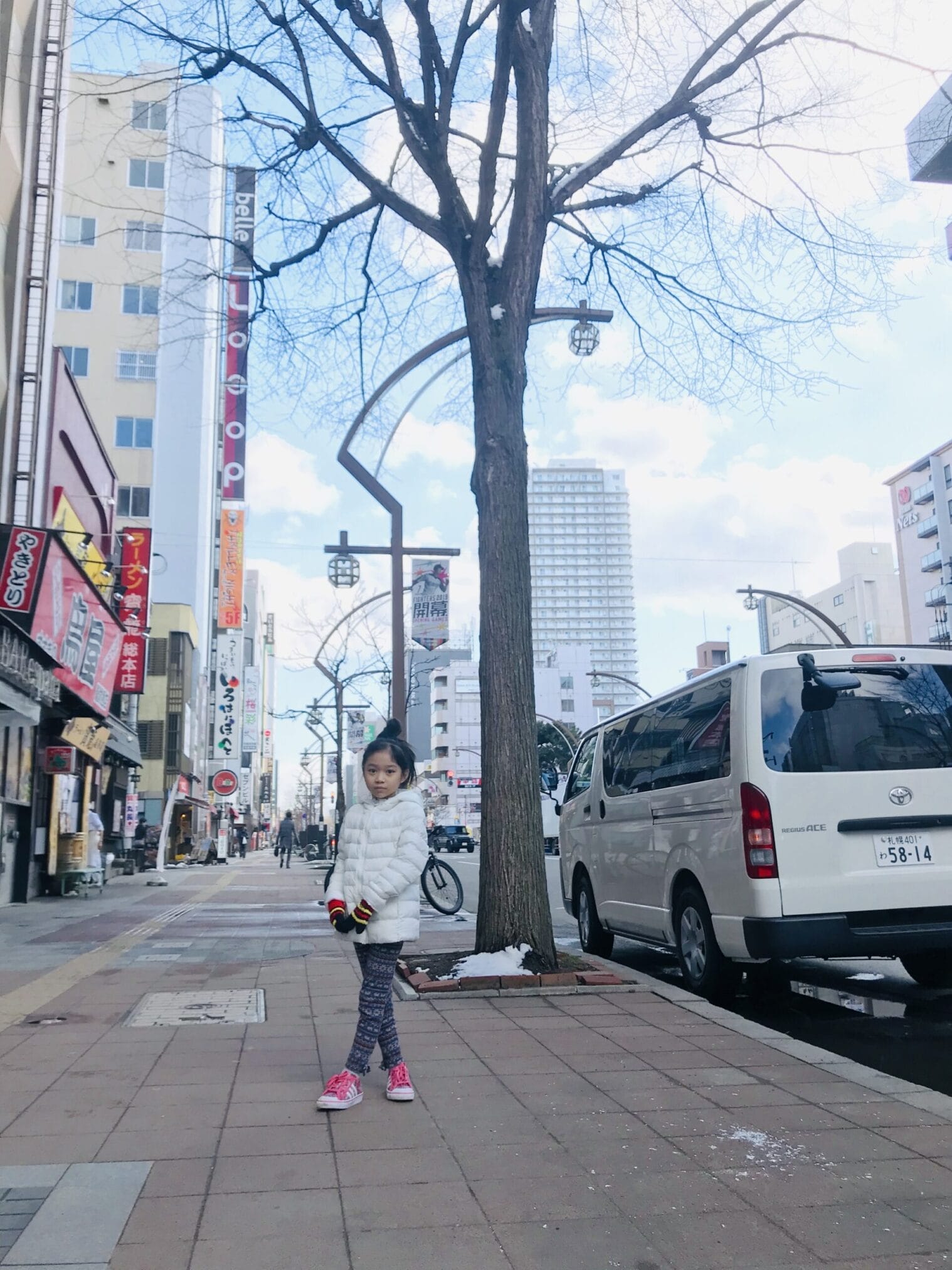 เด็กหญิงยืนอยู่บนทางเท้าในฮอกไกโด ทริปขับรถจากฮอกไกโดถึงโตเกียว