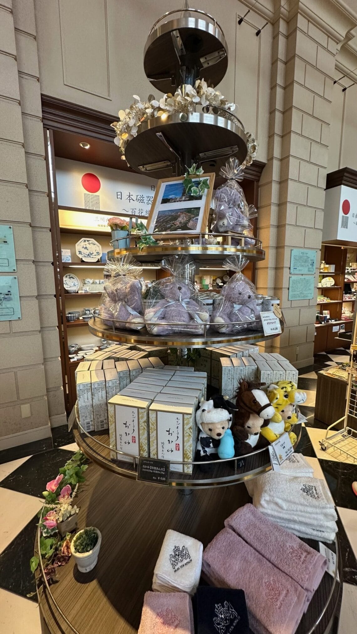 ชั้นวางสินค้าในร้านค้าที่ฟุกุโอกะ มีตุ๊กตา ผ้าขนหนู และของที่ระลึกอื่นๆ จากการขับรถเที่ยวภูมิภาคคิวชู