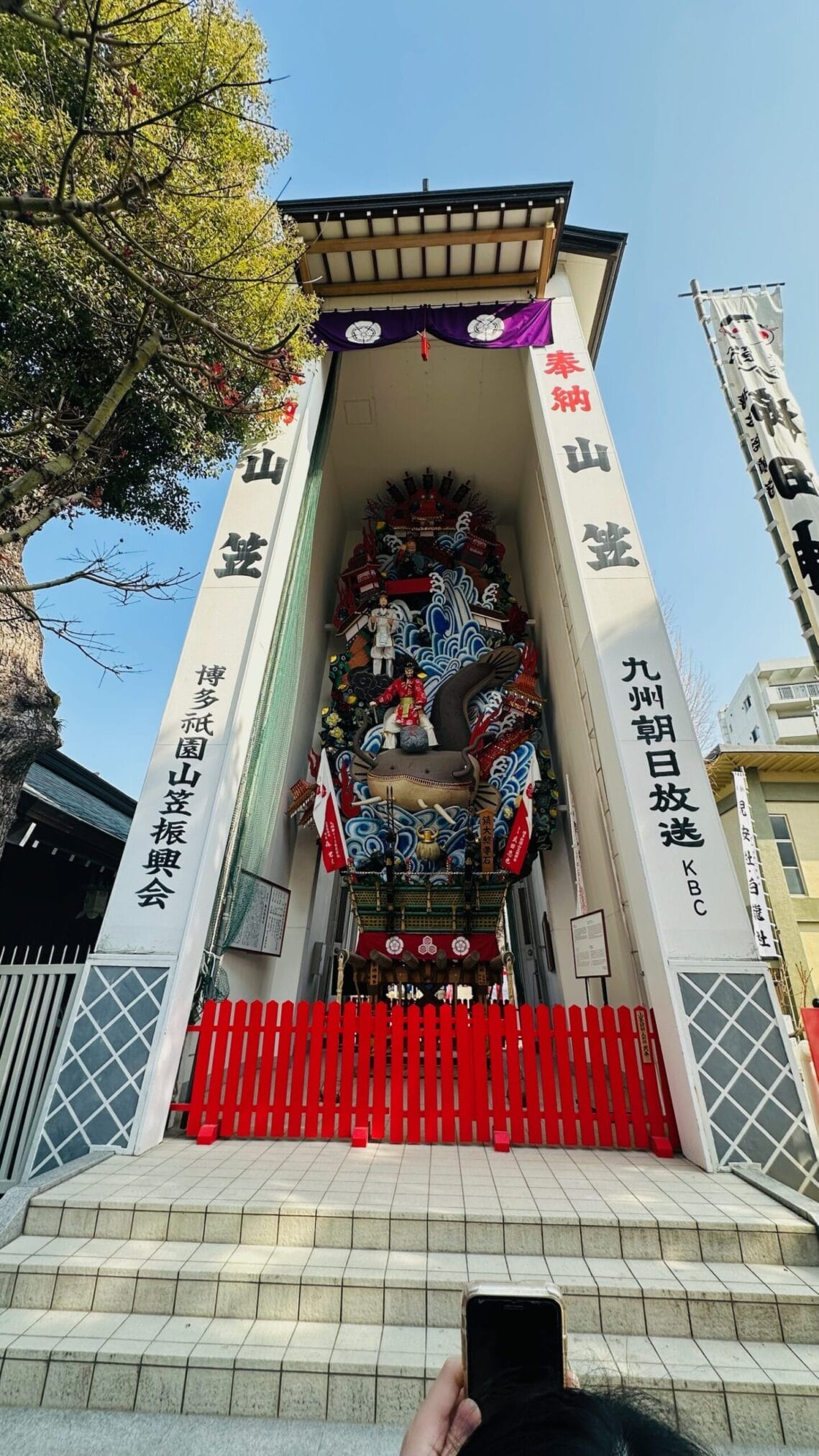ศาลเจ้าในฟุกุโอกะ, คิวชู พร้อมป้าย "奉納山笠" (Hōnō Yamakasa) และ "博多祇園山笠振興会" (Hakata Gion Yamakasa Shinkoukai)