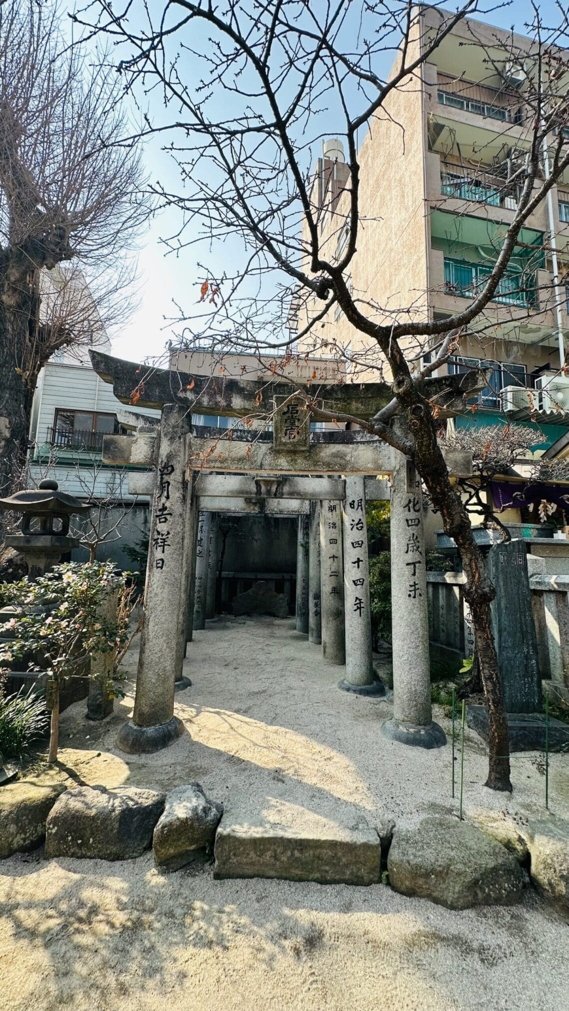 ทางเข้าศาลเจ้าชินโตในฟุกุโอกะ มีเสาหินสลักอักษรญี่ปุ่น "เมจิ" และปีที่สร้าง