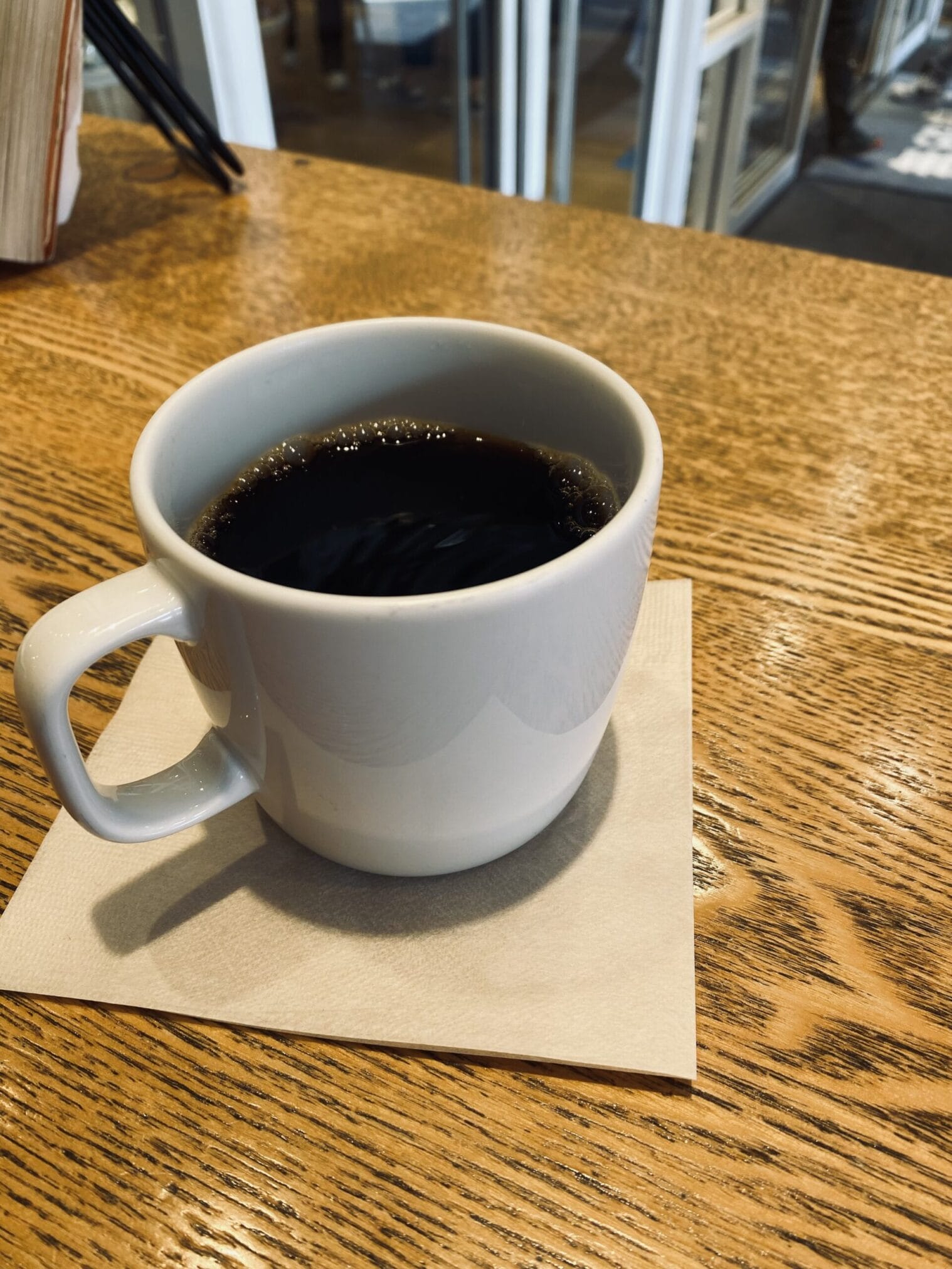 กาแฟดำในถ้วยสีขาวบนโต๊ะไม้ในฟุกุโอกะ, คิวชู