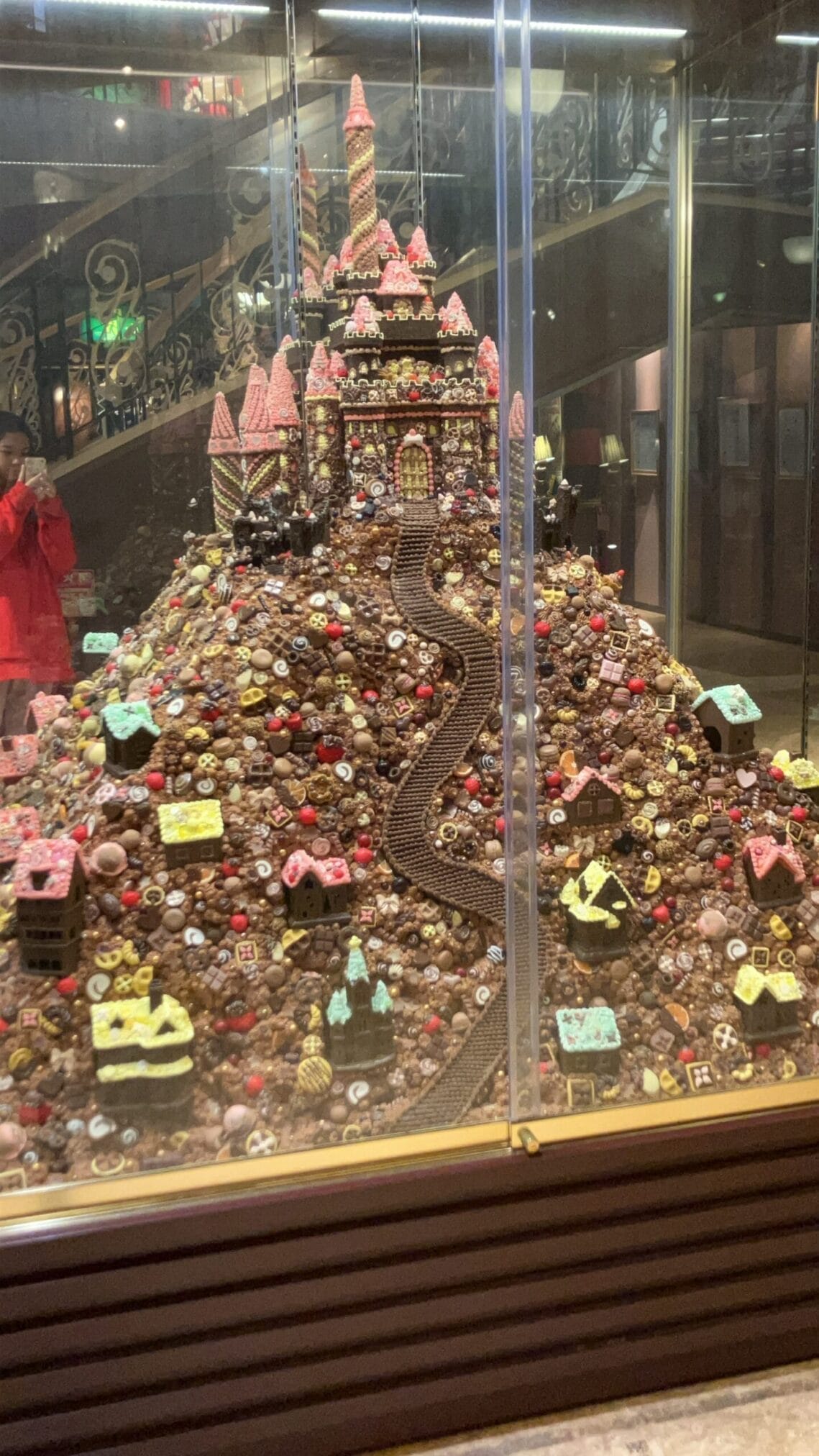 ปราสาทช็อกโกแลตขนาดใหญ่ในตู้โชว์ ตกแต่งด้วยบ้านและลูกกวาด