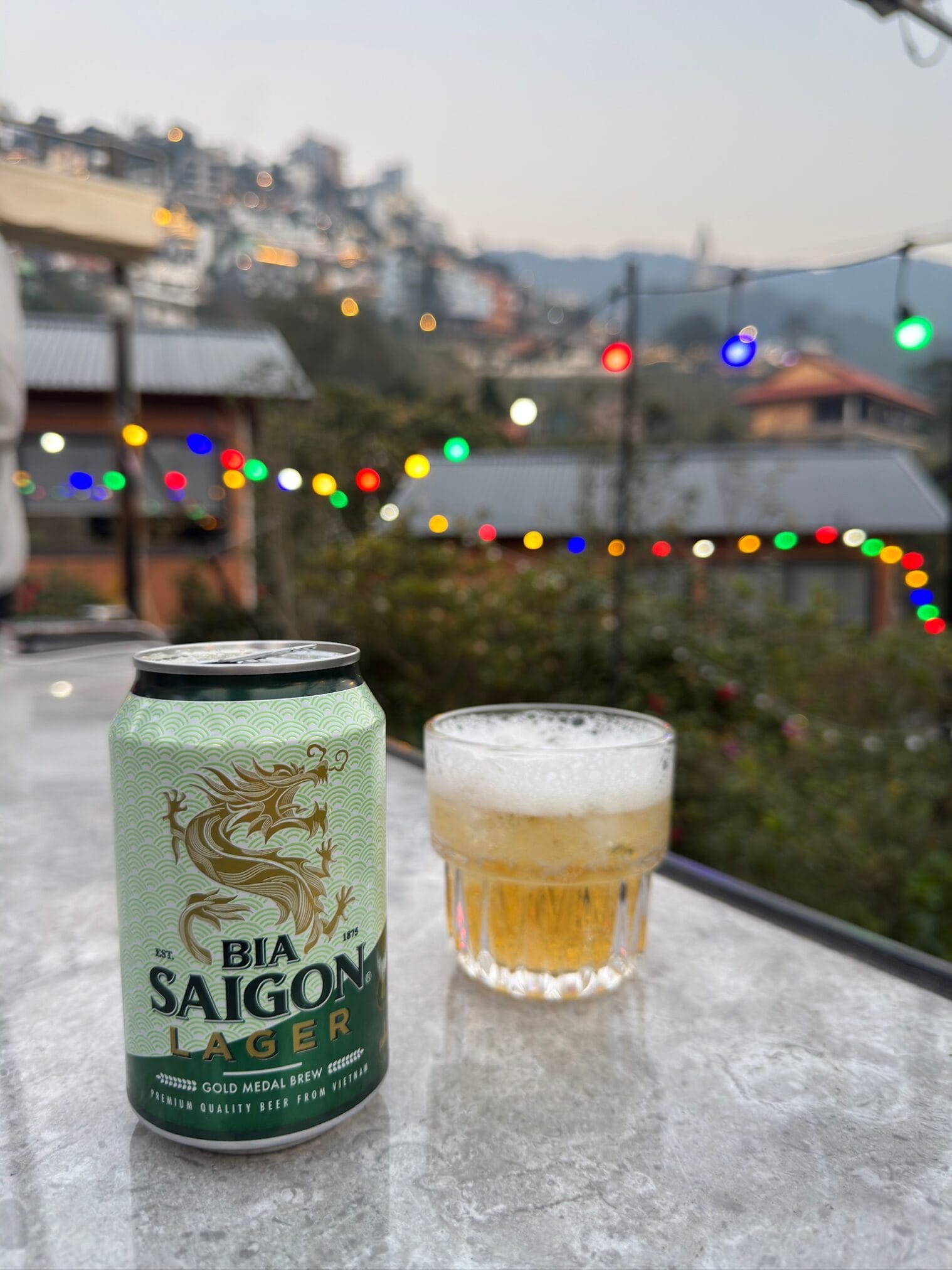 เบียร์ Saigon Lager กระป๋องและแก้ว บนพื้นหลังวิวเมืองฮานอย ตามด๋าว