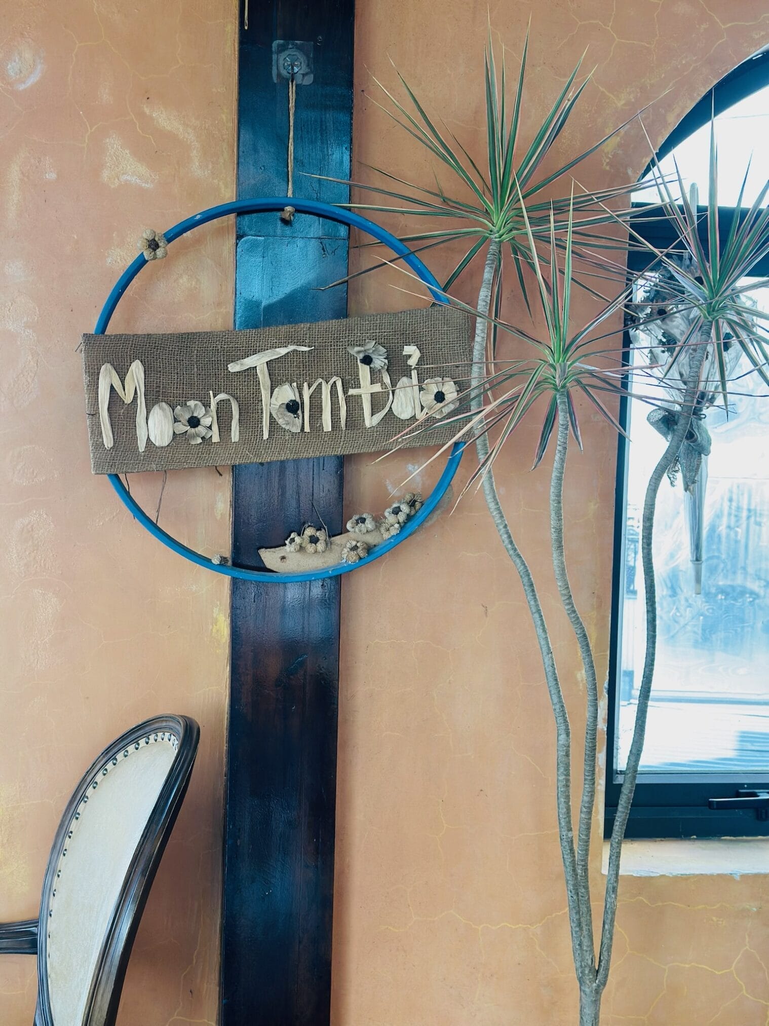 ฮานอย: ป้าย "Moon Tam Đảo" บนผนังสีส้มข้างหน้าต่างและต้นไม้