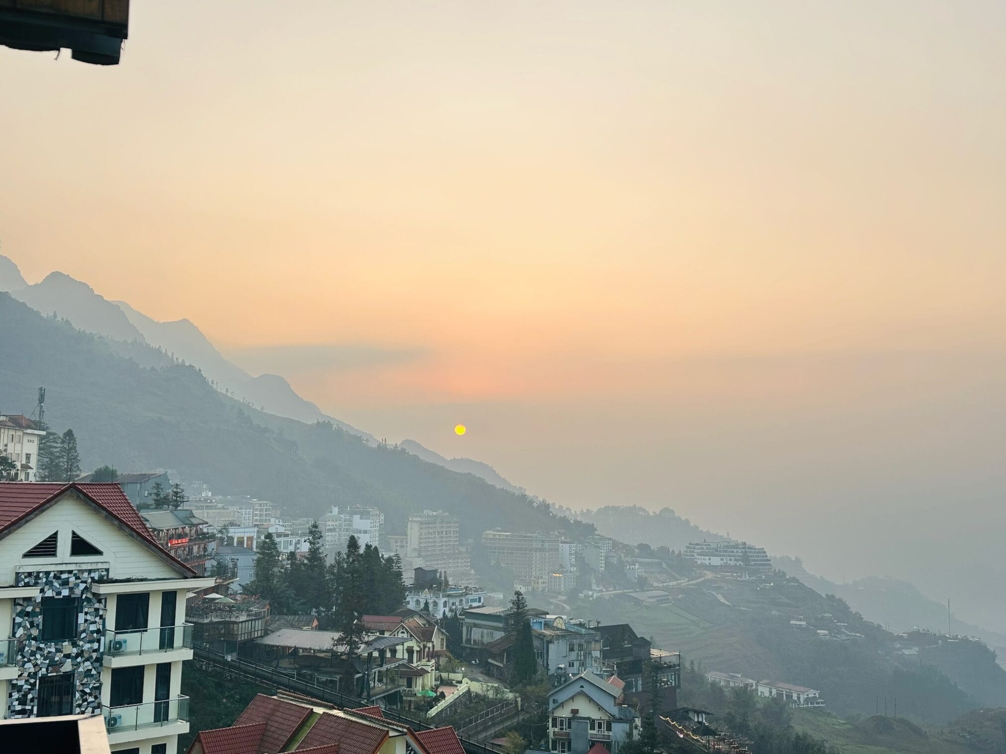 ซาปา เมืองในหุบเขา วิวพระอาทิตย์ขึ้นเหนืออาคารและภูเขา