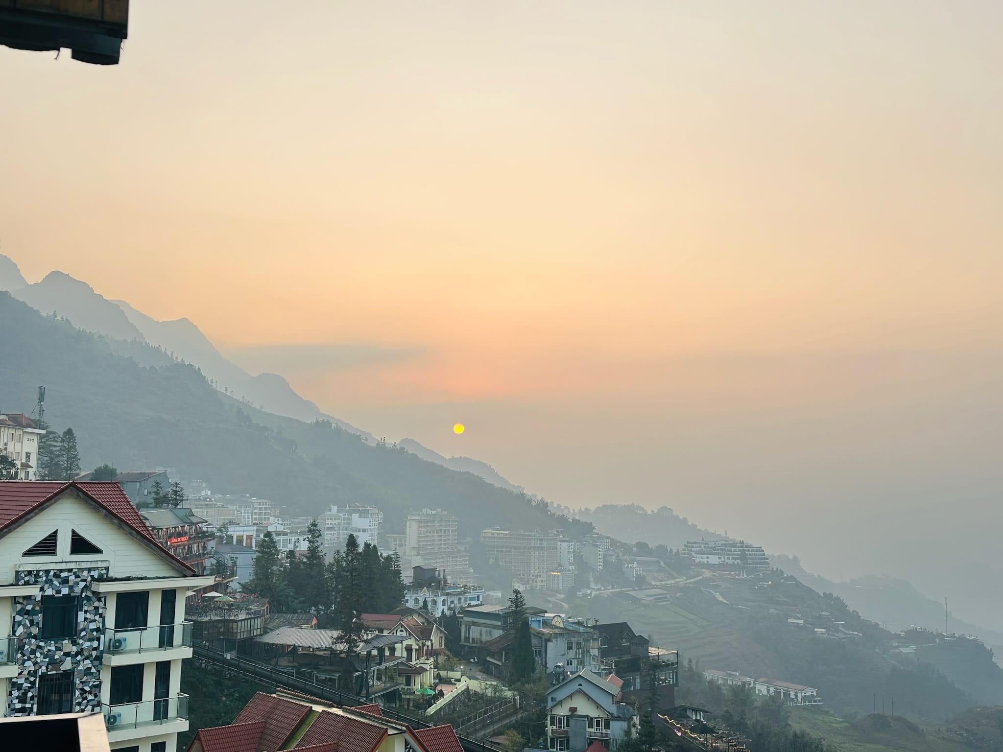 ซาปา เมืองในหุบเขา วิวพระอาทิตย์ขึ้นเหนืออาคารและภูเขา