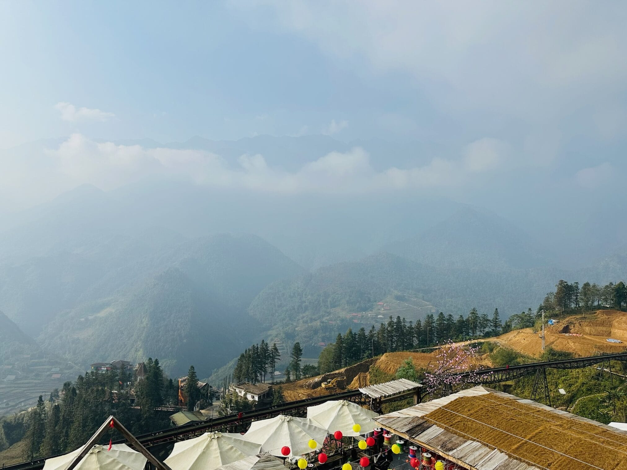 วิวทิวทัศน์ภูเขาเขียวชอุ่มในหมอก, มีอาคารและหลังคาด้านล่าง