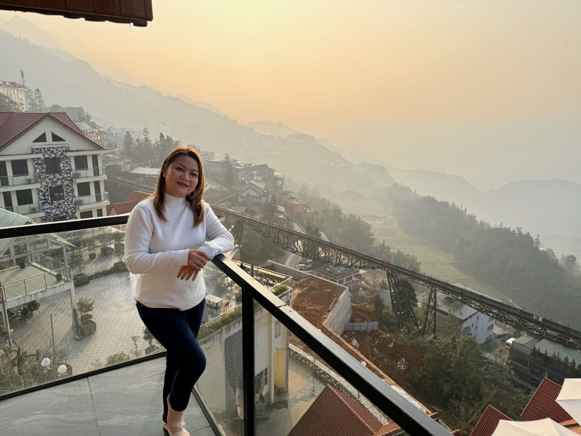 หญิงสาวยืนบนระเบียงชมวิวทิวทัศน์ซาปาในยามเช้า