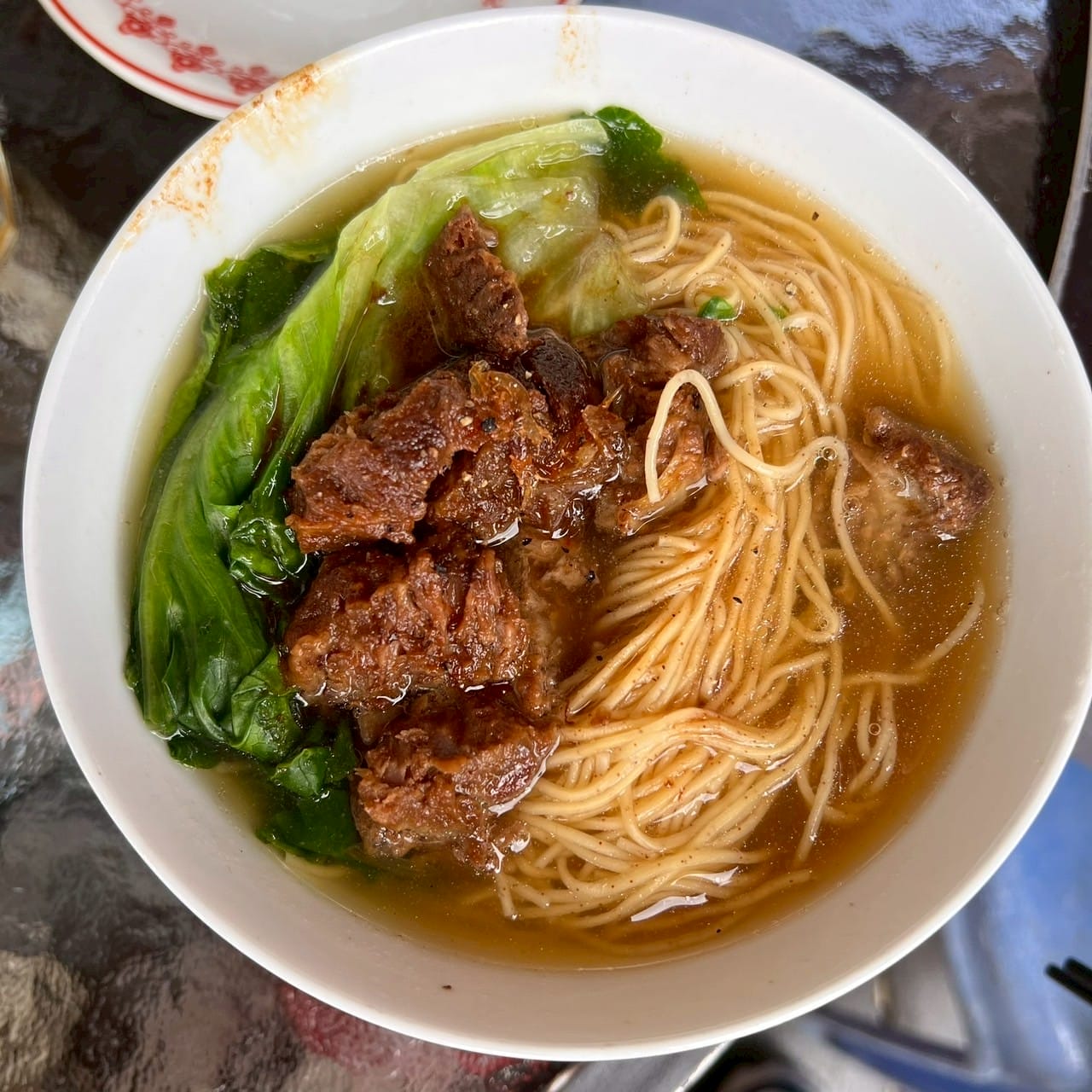 บะหมี่น้ำเนื้อตุ๋นและผักกวางตุ้งในชามขาว Braised beef noodle soup with bok choy in white bowl