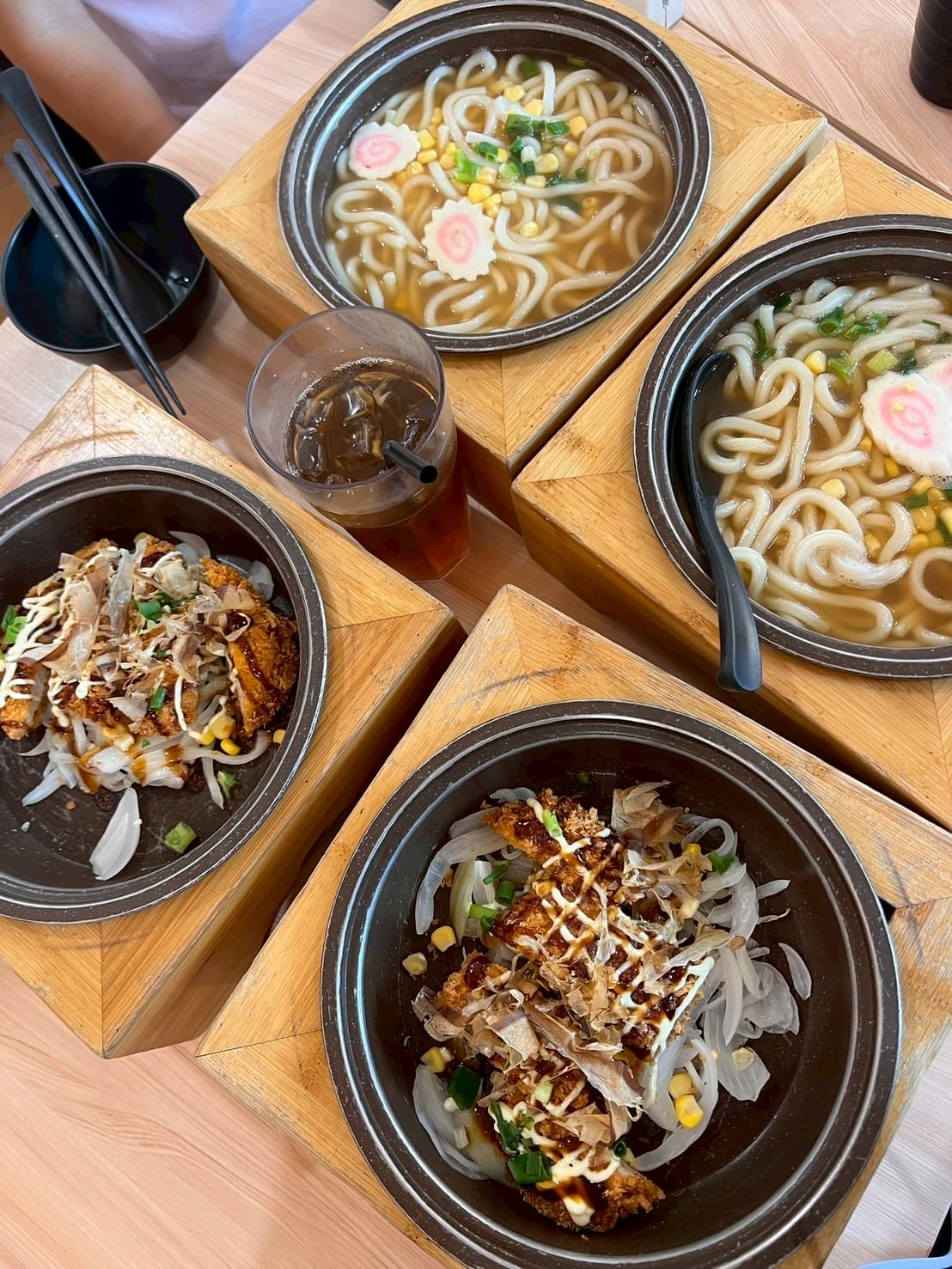 ชามอุด้งน้ำซุปและอุด้งราดหน้าหมูทอดบนโต๊ะไม้