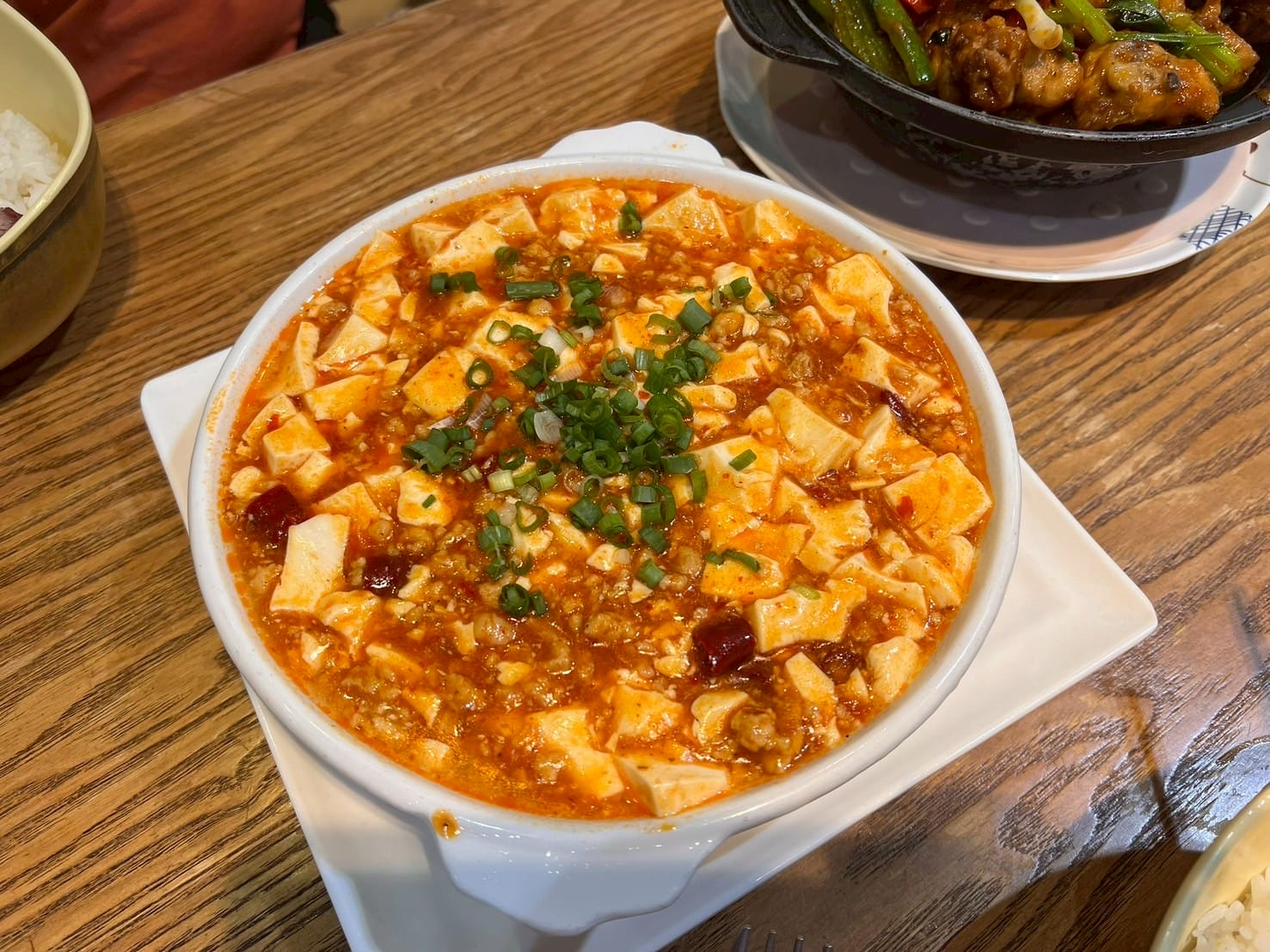 เต้าหู้ผัดเผ็ด Mapo tofu ราดต้นหอมในชามขาว